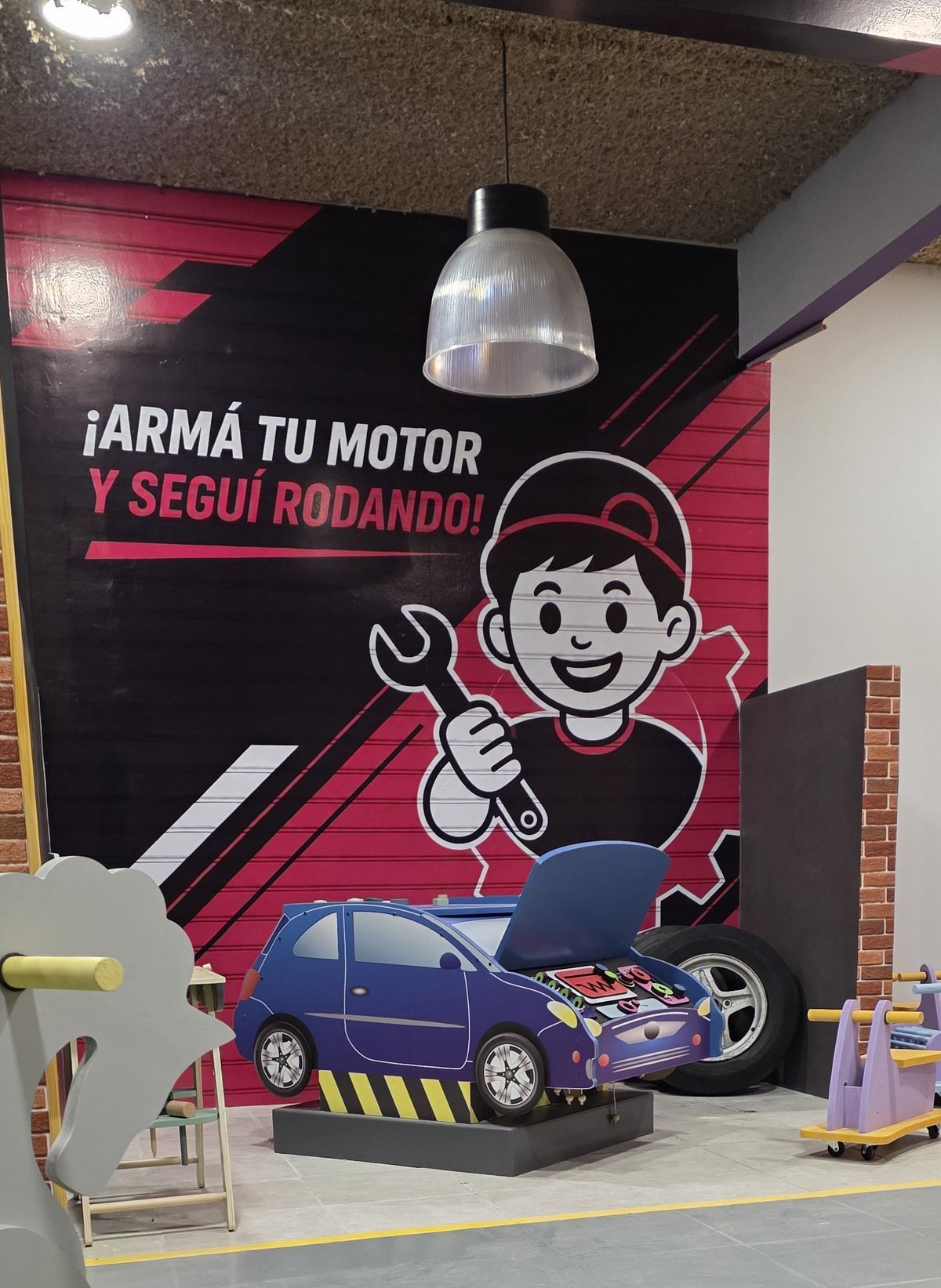Mural del taller mecánico con autito azul y personaje